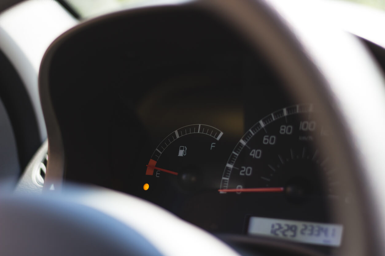 Car fuel gauge showing low fuel remaining