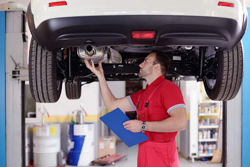 Your vehicle's performance and fuel efficiency will both increase if your exhaust system is functioning properly. It also helps reduce noise and pollution. Mechanic checking exhaust pipe under car