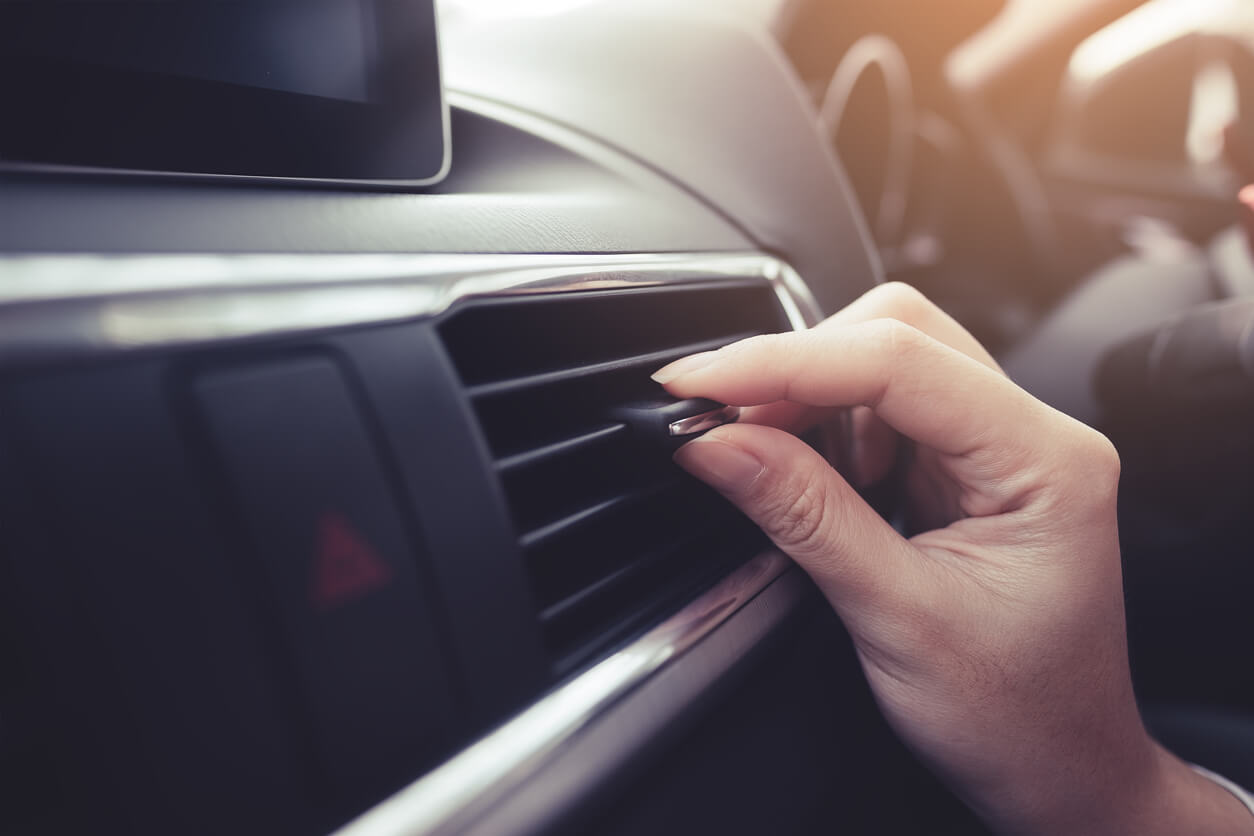 Air Conditioning Servicing Driver adjusting dashboard vent in car to control air conditioning