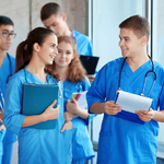 a group of young nurses chatting with clipboards