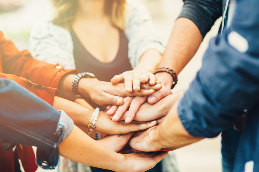 A group of friends putting their hand one over another.