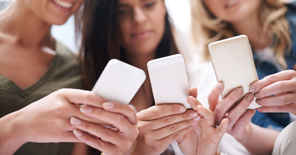 Group of girls using smartphone for social networking