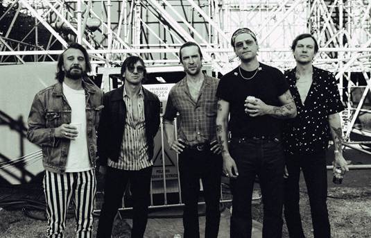 A group of men standing in front of a metal structure<br />
<br />
AI-generated content may be incorrect.