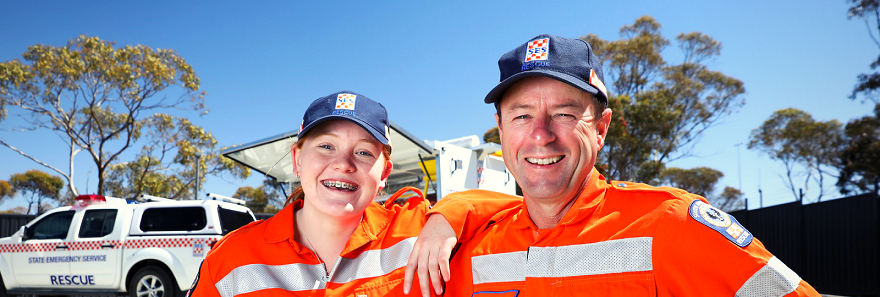 Two SA State Emergency Service volunteers standing in front of a SES vehicle.