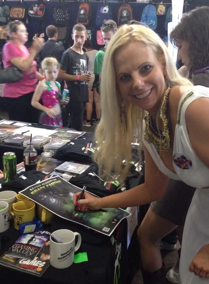 Actress Jo Christiaans signing posters for fans at Comic Con.