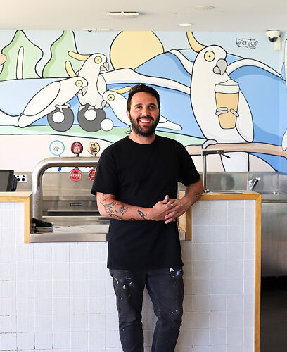 Artist Brent Turner next to his Reeftip Cockatoo Mural