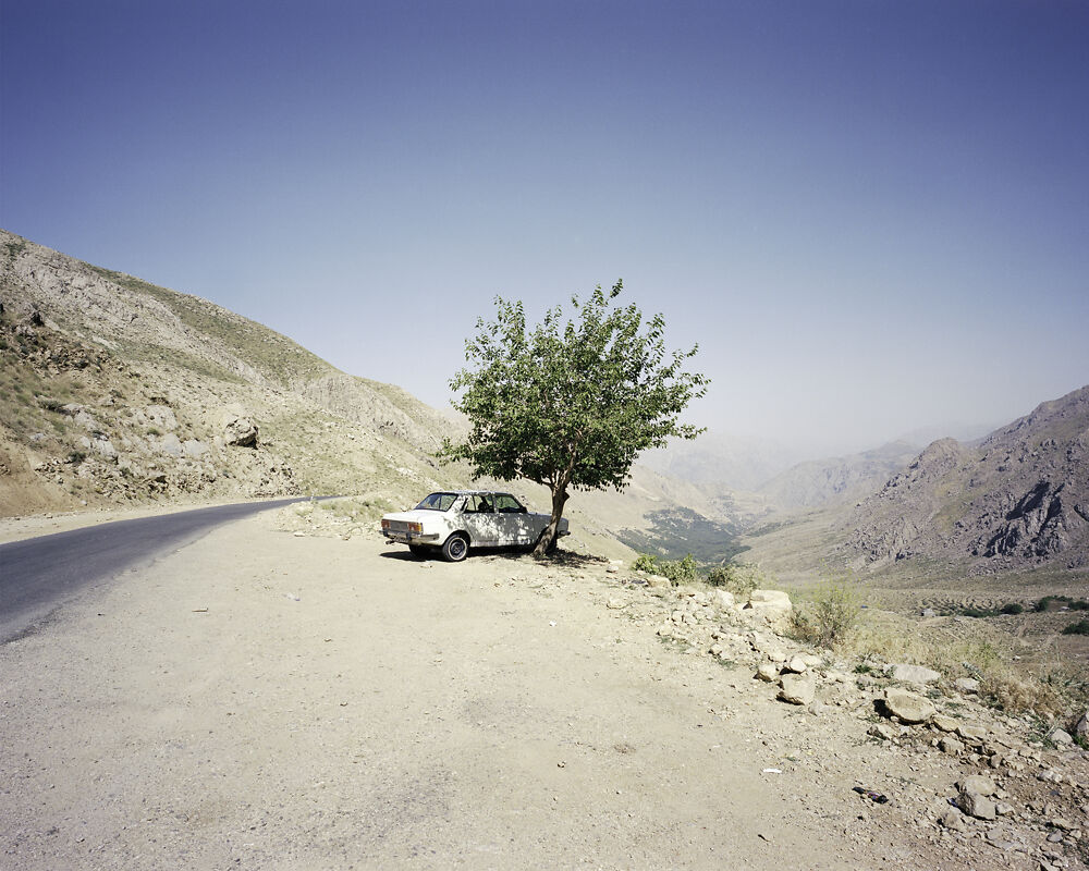 A family's Paykan (translated from Farsi as 'Arrow') sits beneath a tree overlooking the Hawraman Valley, Kurdistan.