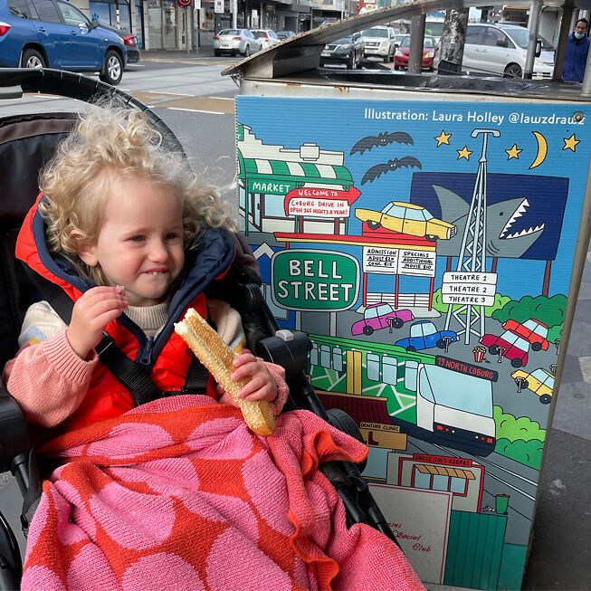 Laura's daughter Maggie poses with her Coburg bin wrap art