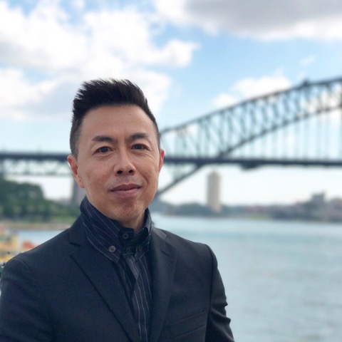 A portrait of Dr Tuck Wah Leong in front of the Sydney Harbour Bridge.