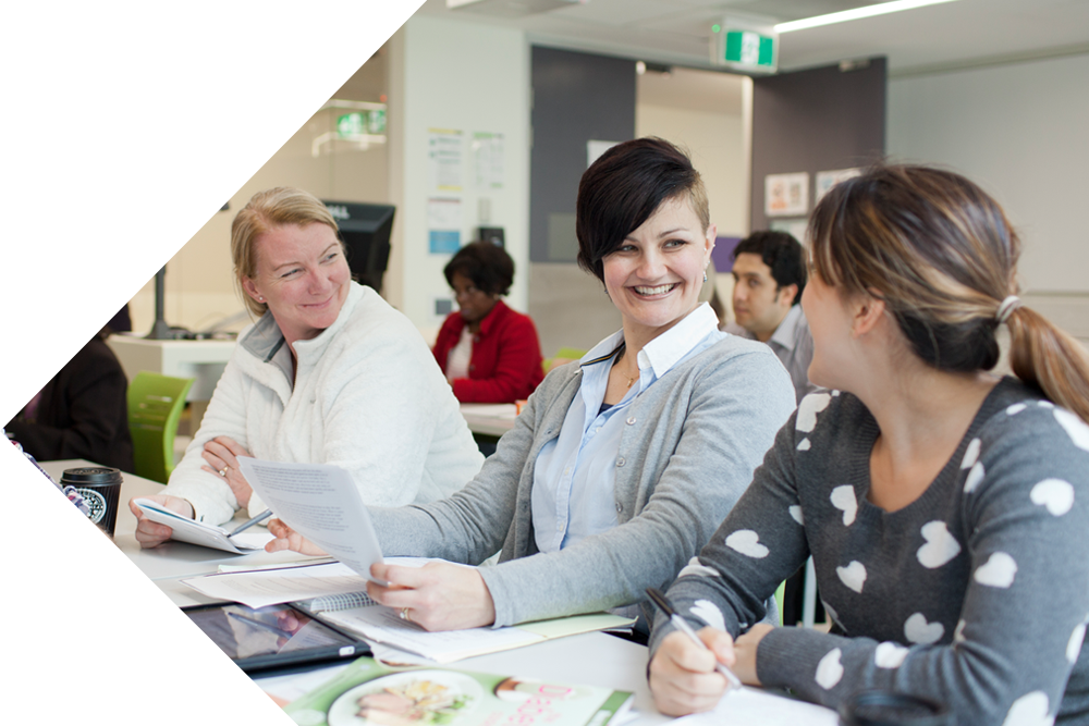 Students in study spaces talking as a group