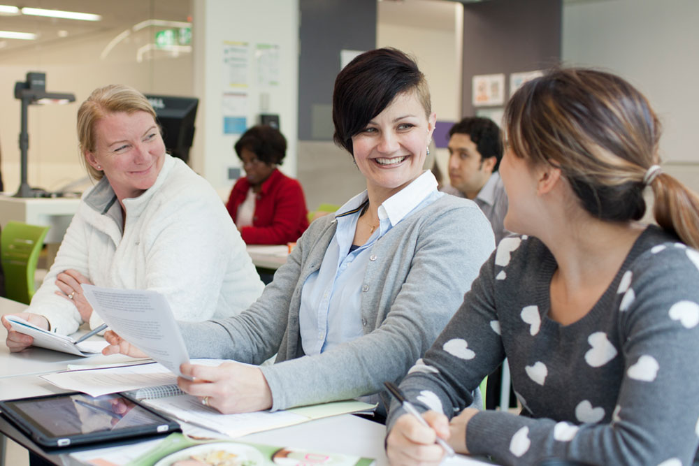 Students in study spaces talking as a group