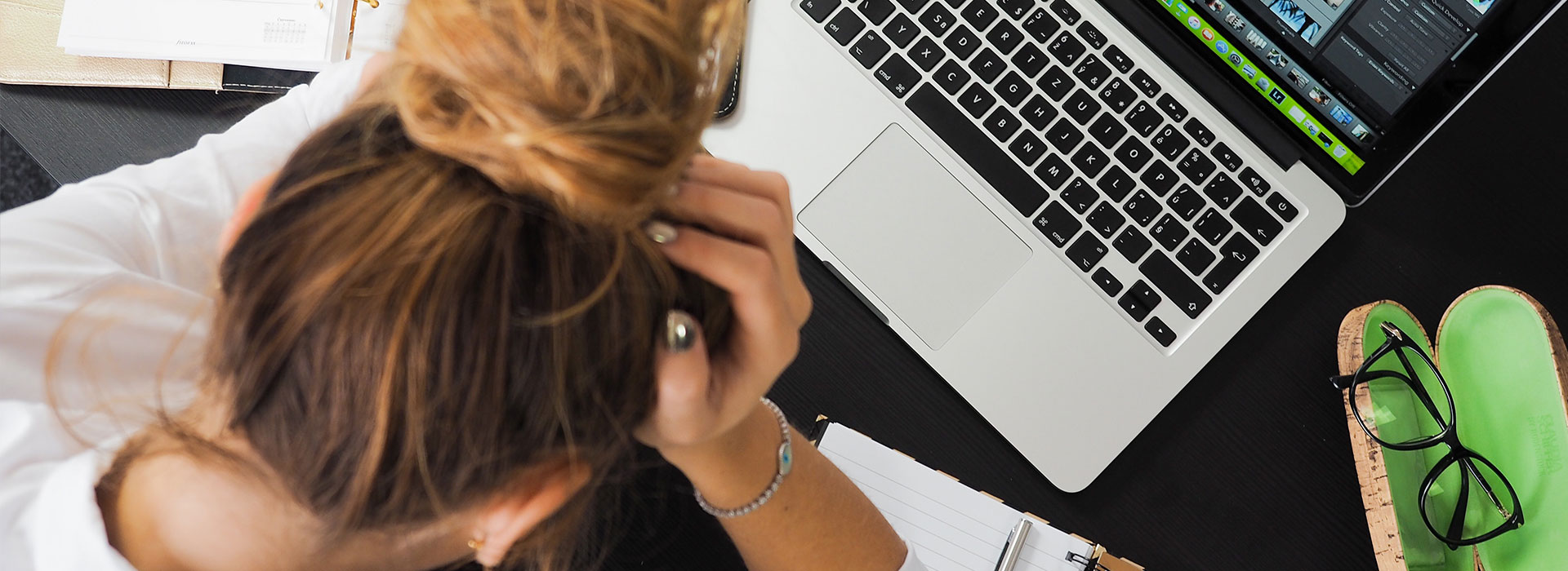 A woman with her head in her hands stressed out.