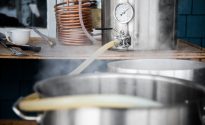 An introduction to homebrewing Home Brewing Kit and Pouring Craft Beer Wort into the Boil Kettle with a Silicone Tube.