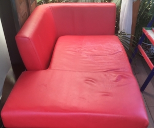 Comfortable but worn red love seat sofa