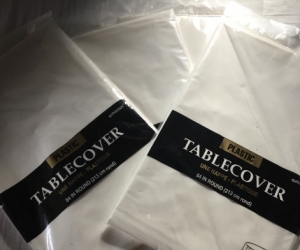 Three round white plastic tablecloths